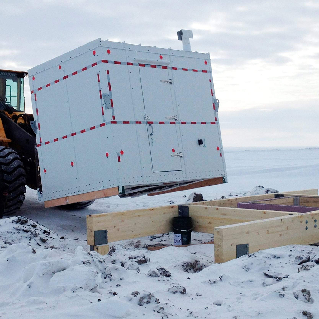 Installation of a shelter covering the entrance to a new community ice cellar. This type of underground food cache was dug into the permafrost to provide natural refrigeration and used for generations in far-north communities. Naturally cooled underground ice cellars, used in Alaska Native communities for generations, are becoming increasingly unreliable as a warming climate and other factors touch multiple facets of life in the far north. (Submitted Photo)