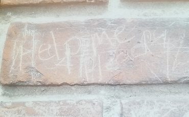 The words “help me” scrawled into the bricks at the Mush Hole.