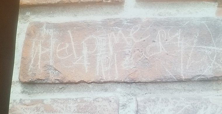 The words “help me” scrawled into the bricks at the Mush Hole.