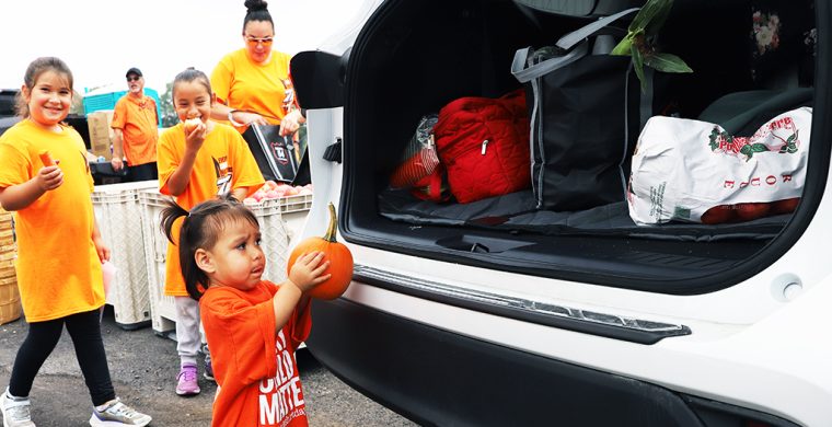 Kris Hill’s family all turned out to help with the huge give-away including grand kids - little Willow with her pumpkin and Grace and Sophia. (Photo by Jim C. Powless)