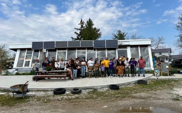 Attendees and workshop co-ordinators along with family pose outside the Mohawk Seedkeeper earthship Saturday during the 9th annual seed exchange.