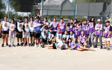 OMSK and Kawenni:io’s teams pose together after the game, medals in hand.