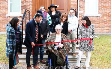 Former MCFN councillor Carol Tobicoe cuts the ribbon in front of the reopened Council House.