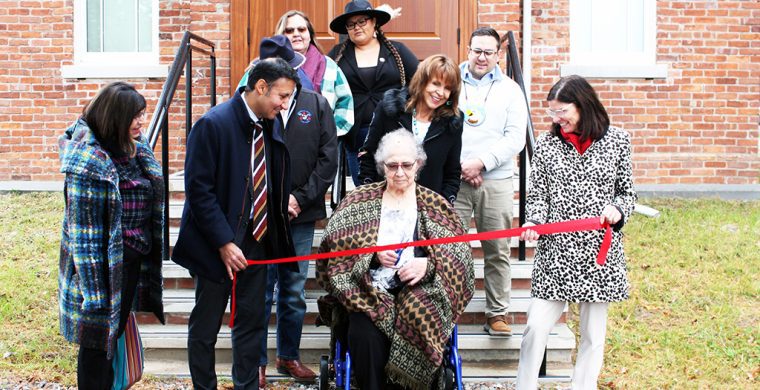 Former MCFN councillor Carol Tobicoe cuts the ribbon in front of the reopened Council House.