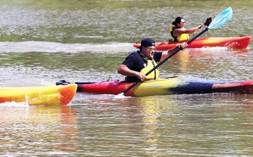 Six Nations firefighter Chancy Johnson, centre, takes and holds an early lead during the adult kayak race at Six nations Water festival on July 3 at Chiefswood Park. Johnson made first place to cheers from dock-filled audience - including some of his colleagues. (Photo by Jim C. Powless)