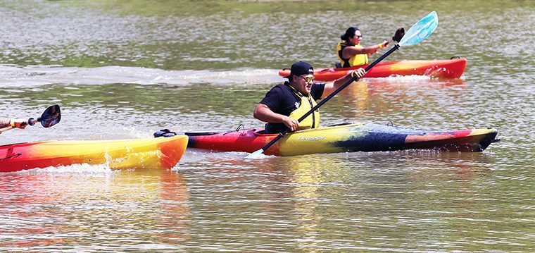 Six Nations firefighter Chancy Johnson, centre, takes and holds an early lead during the adult kayak race at Six nations Water festival on July 3 at Chiefswood Park. Johnson made first place to cheers from dock-filled audience - including some of his colleagues. (Photo by Jim C. Powless)