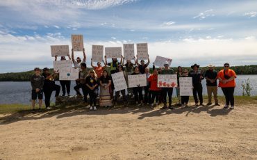Youth Rising Together brought together local youth and supporters for a community rally in Mattagami FN on August 18, 2025. The group is pictured here with Chief Jennifer Constant (in front with the Mattagami FN broach) overlooking Mattagami Lake. (Photo by Trentin Thomas)