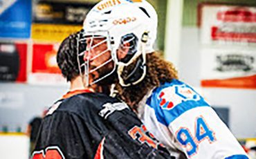 Six Nations Chiefs' defender Tyson Bell (white jersey) hugs an opponent from the Owen Sound North Stars following his team playoff series sweep on Saturday. Photo by Darryl Smart.