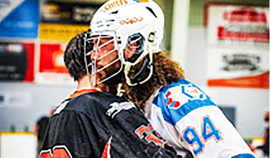 Six Nations Chiefs' defender Tyson Bell (white jersey) hugs an opponent from the Owen Sound North Stars following his team playoff series sweep on Saturday. Photo by Darryl Smart.