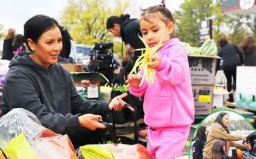 It’s all about family. Route 54 Variety owner Kris Hill’s annual Harvest food give-away fed over 700 families. Volunteers and family, like daughter Markie Styres and her four-year-old daughter Willow, filled bags of food placed in cars by Kris Hill and two more granddaughters. (Photo by Jim C. Powless)