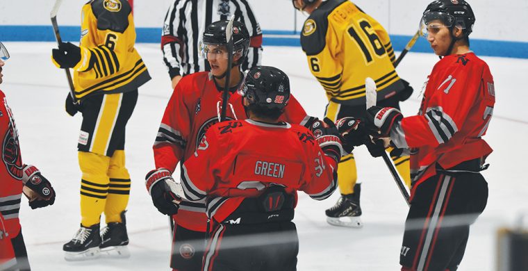 Members of the Six Nations Ironmen celebrate a goal on Sunday. Pictured are goalscorer Mitch Green, as well as Theo Hill on left, and Brenden Anderson on right. (Photo by Honee Anderson).