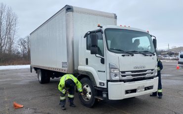 Inspectors check out tires, including tred on trucks pulled over last week. (Photos by Jim C. Powless)