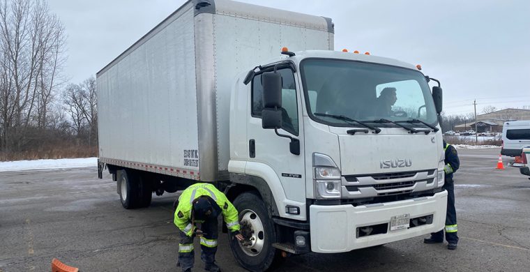 Inspectors check out tires, including tred on trucks pulled over last week. (Photos by Jim C. Powless)