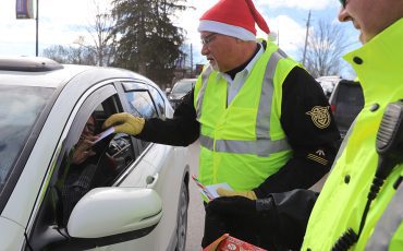 Six Nations police, firefighters and ambulance services were all on hand Friday on Chiefswood Road in front of the Iroquois Village Plaza stopping traffic, but not for tickets, instead they were giving out a bit of Christmas Cheer, handing out Tim’s Cards and promoting safety over the holidays. (Photos by Jim C. Powless)