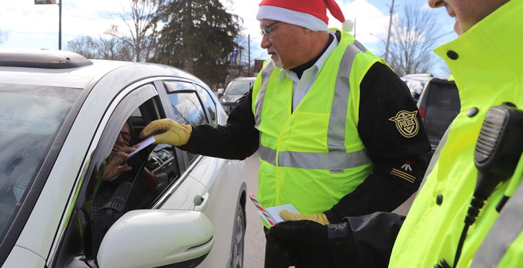 Six Nations police, firefighters and ambulance services were all on hand Friday on Chiefswood Road in front of the Iroquois Village Plaza stopping traffic, but not for tickets, instead they were giving out a bit of Christmas Cheer, handing out Tim’s Cards and promoting safety over the holidays. (Photos by Jim C. Powless)