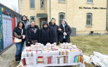 Six Nations librarian, Feather Maracle (second from left) , along with staff and supporters like Dakota Brant (right) marked the public library’s 60th anniversary outside the now closed building. (Photos by Alex Murray)