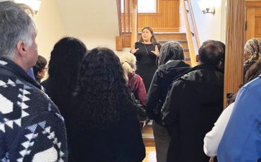 Sam Hill, left, and the BIPOC committee hear the history of the building they are touring along with Sam Hill’s mother who attended as a student.