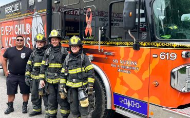 Calvin Thomas and trainees Evan Gibson, Matt Scanlin, and Sophia Xhekaj stand next to one of the newest additions to SNF’s fleet.