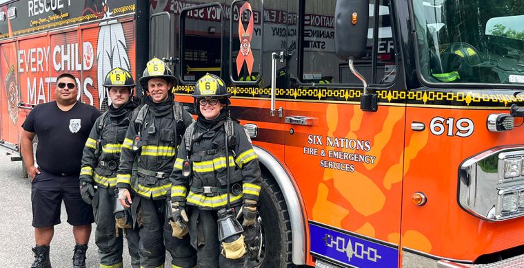 Calvin Thomas and trainees Evan Gibson, Matt Scanlin, and Sophia Xhekaj stand next to one of the newest additions to SNF’s fleet.