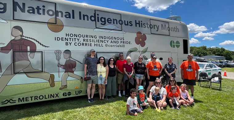 Artist Corrie Hill and her extended family posed in front of the Metrolinx bus featuring her work. (Photo by Alex Murray)
