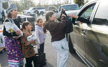 Miss Teen Six Nations, Raynee Smith, along with helpers Kris Hill’s granddaughters Lillie, Sophia and a friend, Ariella, were among the volunteers helping hand out hundreds of bags of harvest foods during the annual Route 54 Variety and Gas Thanksgiving give-away. The tons of vegetables and fruits drew a long line of cars along Highway 54 waiting to get in Saturday. (Photo by Jim C. Powless)