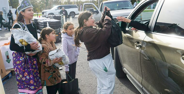 Miss Teen Six Nations, Raynee Smith, along with helpers Kris Hill’s granddaughters Lillie, Sophia and a friend, Ariella, were among the volunteers helping hand out hundreds of bags of harvest foods during the annual Route 54 Variety and Gas Thanksgiving give-away. The tons of vegetables and fruits drew a long line of cars along Highway 54 waiting to get in Saturday. (Photo by Jim C. Powless)